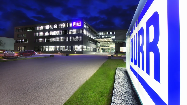 Dürr location headquarters in germany at night viewing the shining logo in the front of the building.